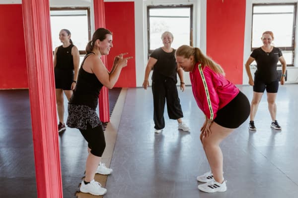 Two smiling women chatting and laughing during a dance class in the Red Studio in Brno